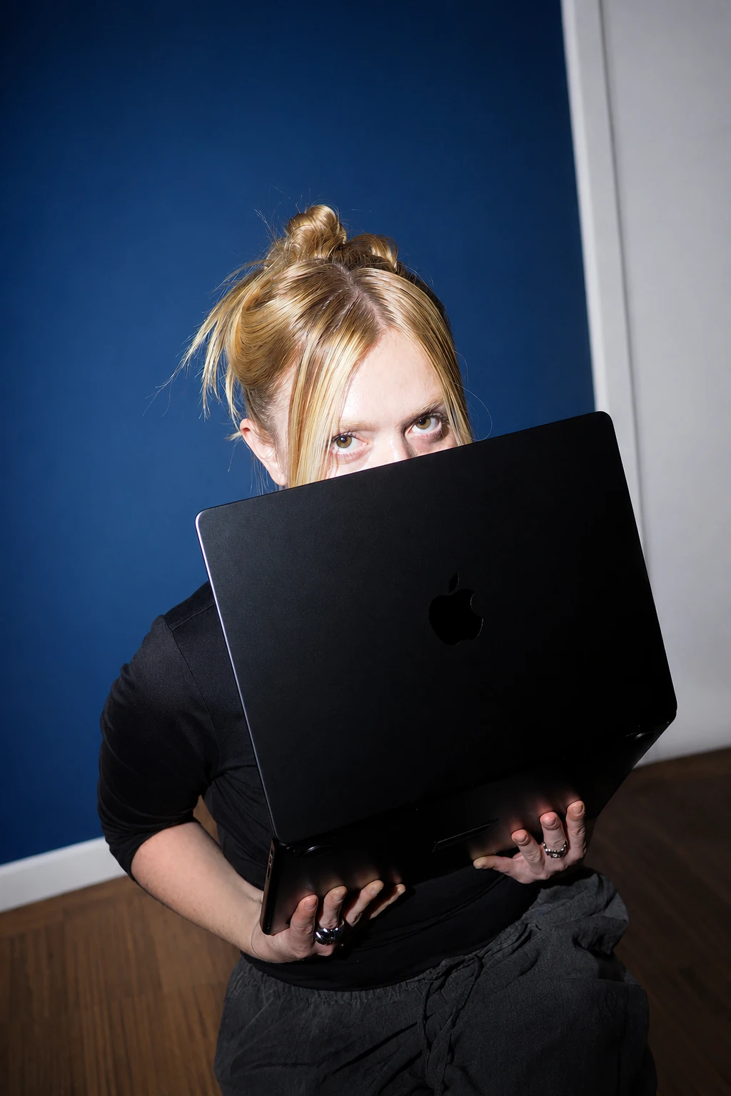 Mitarbeiterin von ZFutura schaut hinter einem Laptop hervor